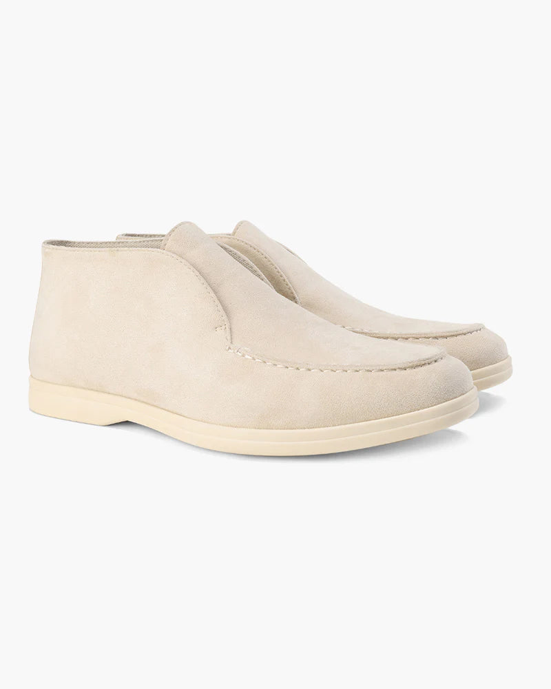 Pair of beige slip-on shoes on a white background