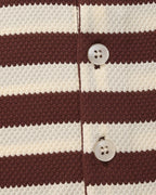 Close-up of a brown and white striped fabric with buttons.