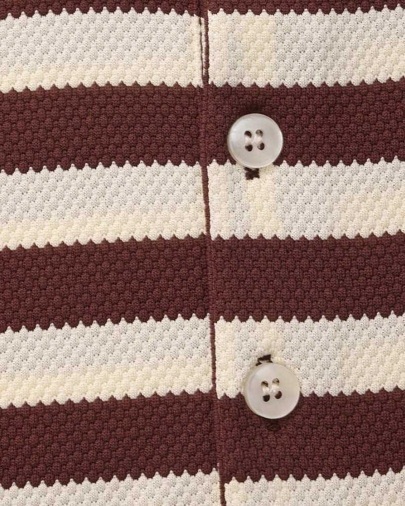 Close-up of a brown and white striped fabric with buttons.