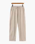 Beige pants on a hanger against a white background
