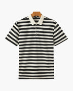 Black and white striped polo shirt on a hanger against a white background