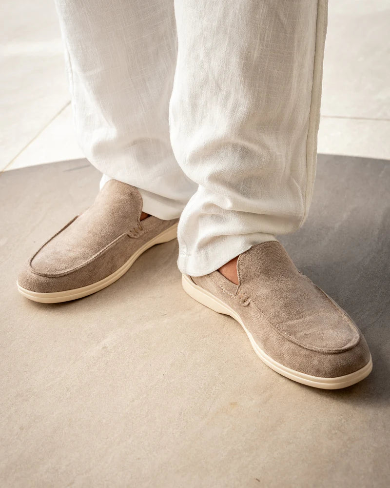 Man wearing brown suede loafers with tailored trousers.