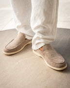 Man wearing brown suede loafers with tailored trousers.