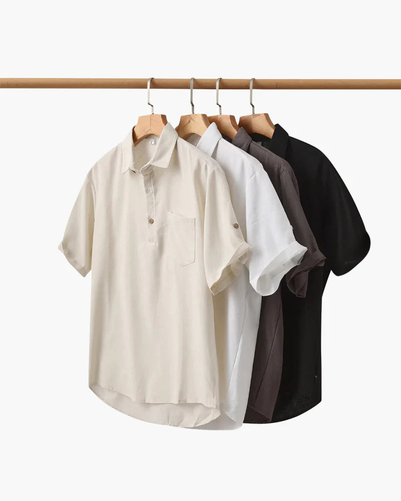 Set of four short-sleeve shirts in beige, white, brown, and black hanging on a rack.