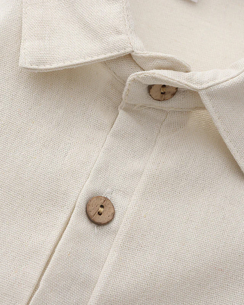 Close-up of a beige shirt with wooden buttons on a light background
