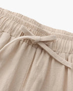 Close-up of beige pants with an elastic waistband on a white background