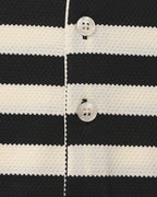 Close-up of a black and white striped fabric with buttons.