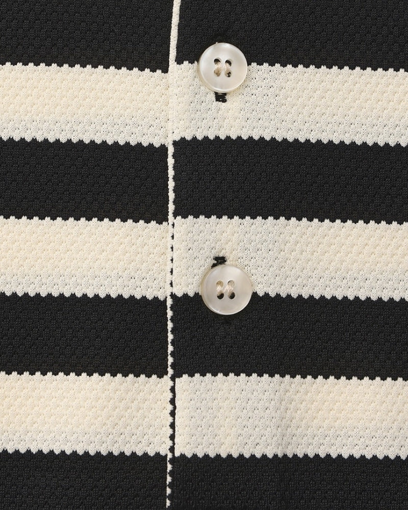 Close-up of a black and white striped fabric with buttons.