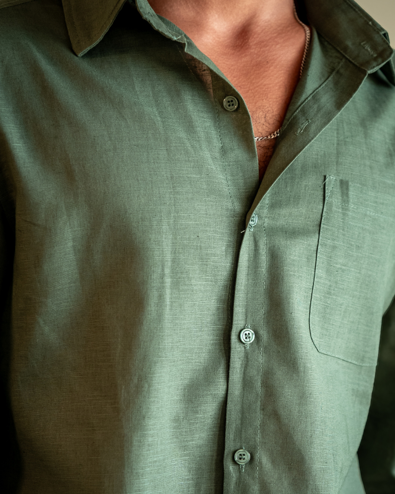 Green button-up shirt worn by a person, with a focus on the collar and buttons.