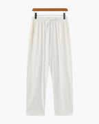 White pants on a hanger against a white background