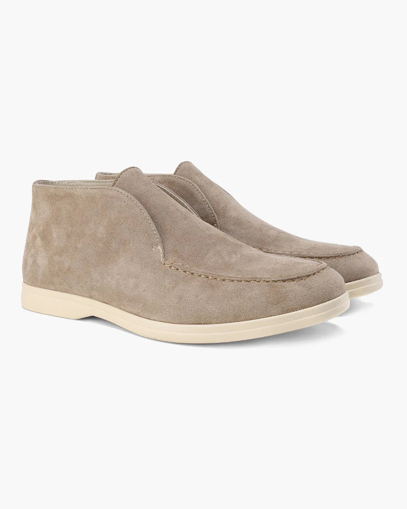 Pair of beige suede shoes on a white background