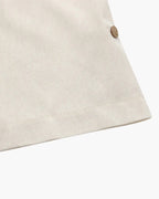 Close-up of a beige fabric with a button on a white background