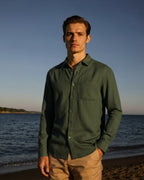 Man standing on a beach with ocean and sky in the background