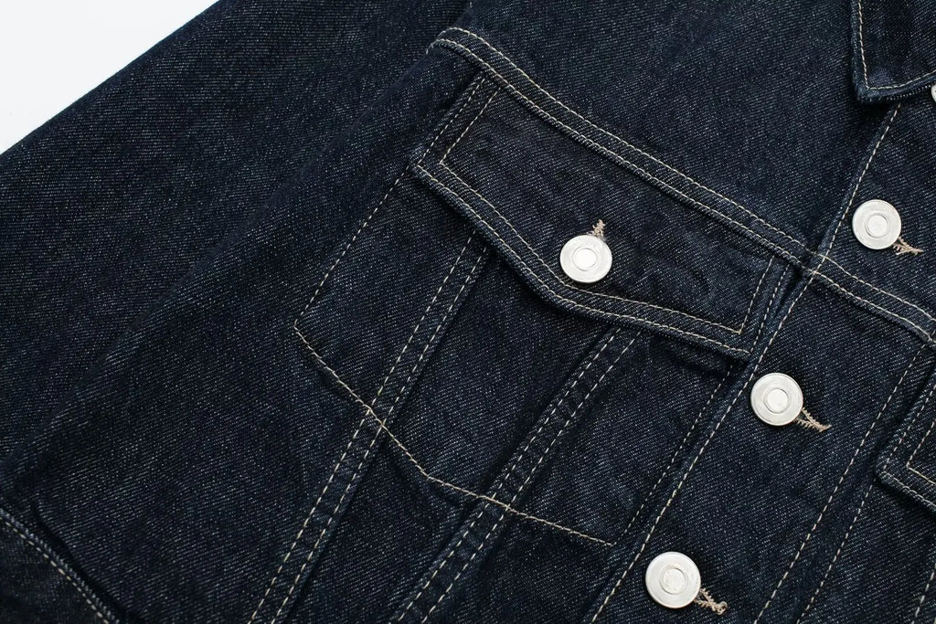 Close-up of a dark blue denim jacket with button details on a white background
