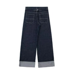 Dark blue jeans with rolled-up cuffs on a white background