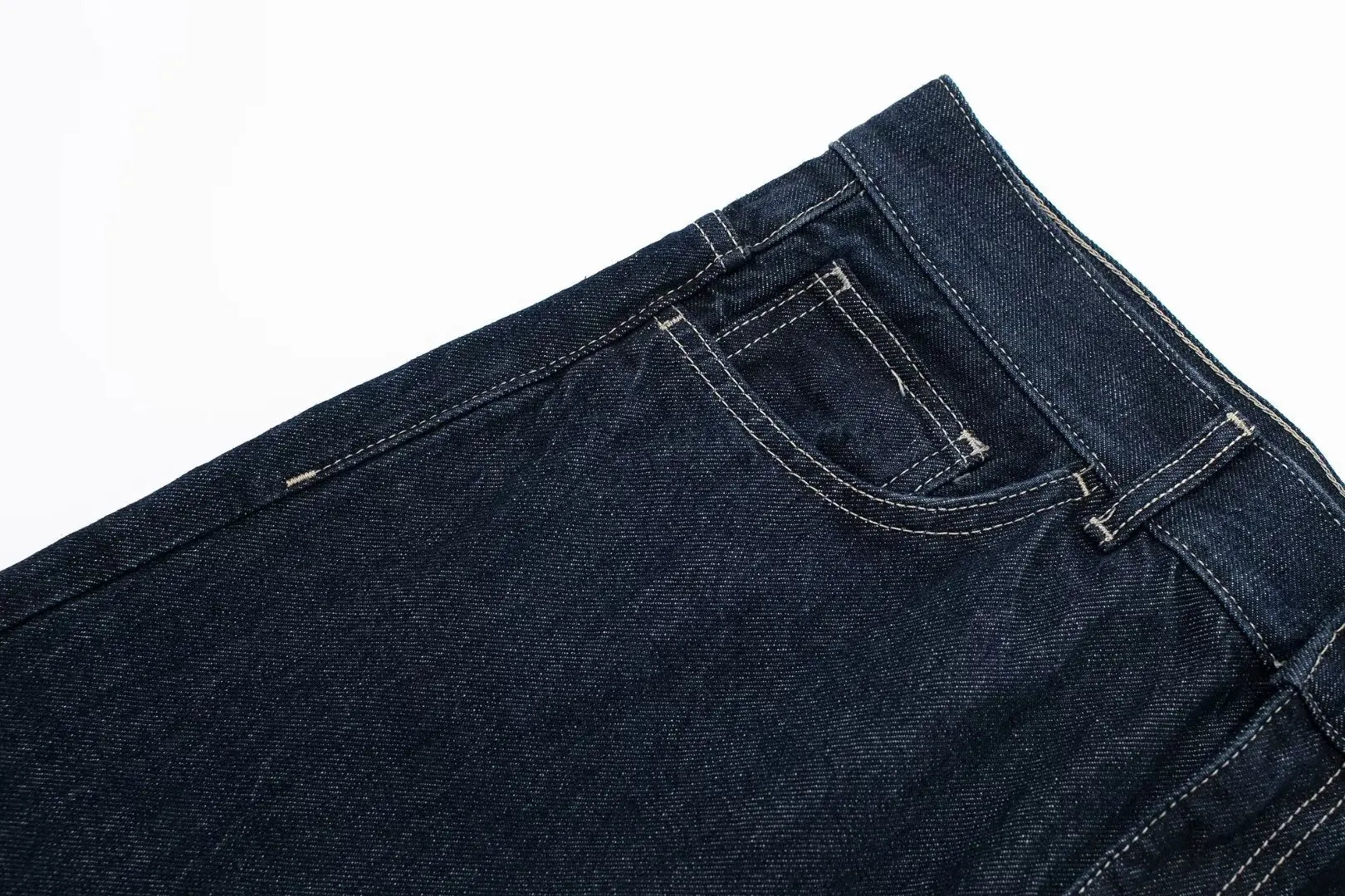 Close-up of dark blue jeans on a white background