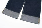 Close-up of dark blue jeans with gray cuffs on a white background