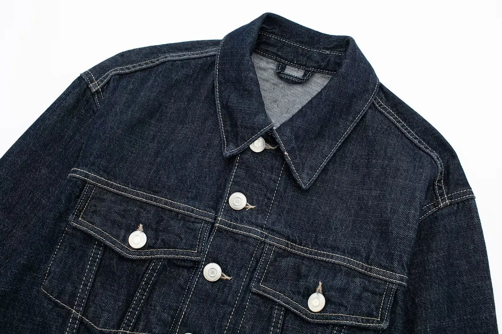 Dark blue denim jacket with button details on a white background