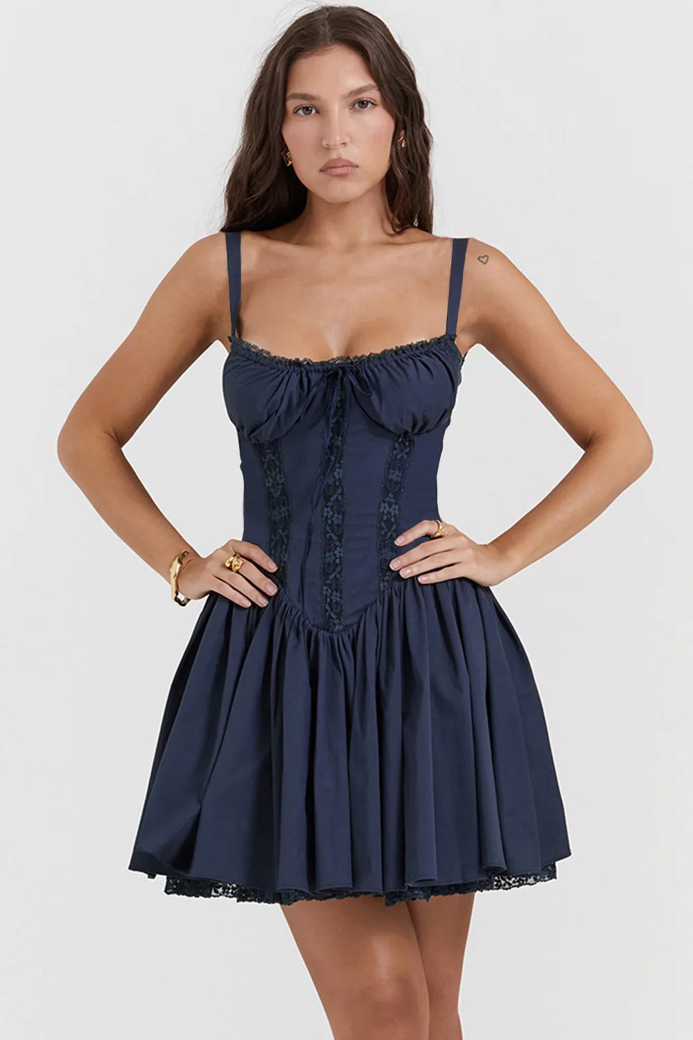 Woman wearing a navy blue dress with lace details on a white background