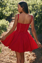 Woman in a red dress standing in a vineyard