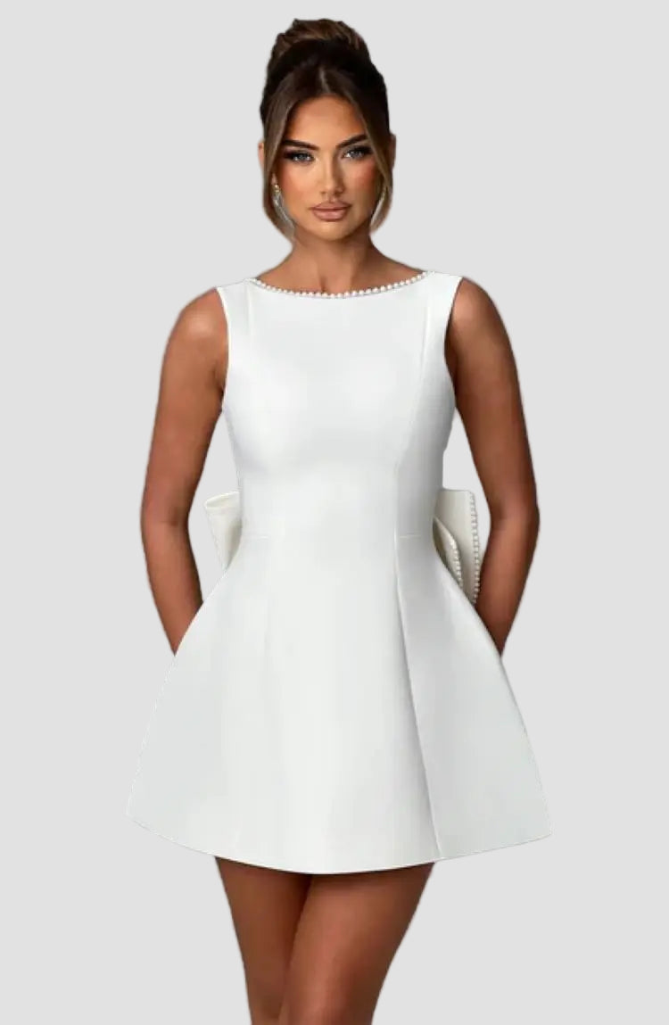 Woman wearing a white dress against a gray background