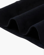 Close-up of dark blue fabric with folds on a white background