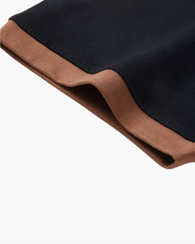Close-up of a black fabric with brown trim on a white background