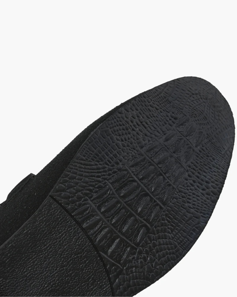 Close-up of a black shoe sole with textured pattern on a white background