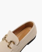 Beige loafer with gold buckle on a white background