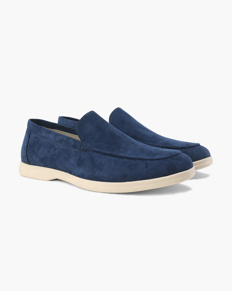 Pair of blue suede loafers on a white background