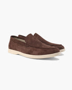 Pair of brown suede loafers on a white background