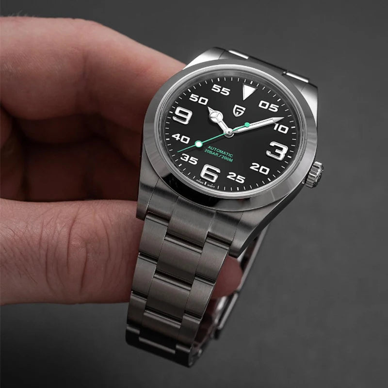 Silver wristwatch with black dial held by a hand against a dark background