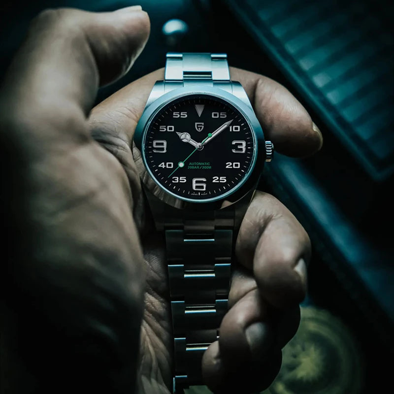 Hand holding a black wristwatch with a dark background