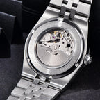 Close-up of a silver watch with visible brand name on a dark background