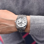 Silver watch on a person's wrist with a blurred background