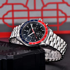Silver watch with a red and black face on a black stand against a red and gray geometric background