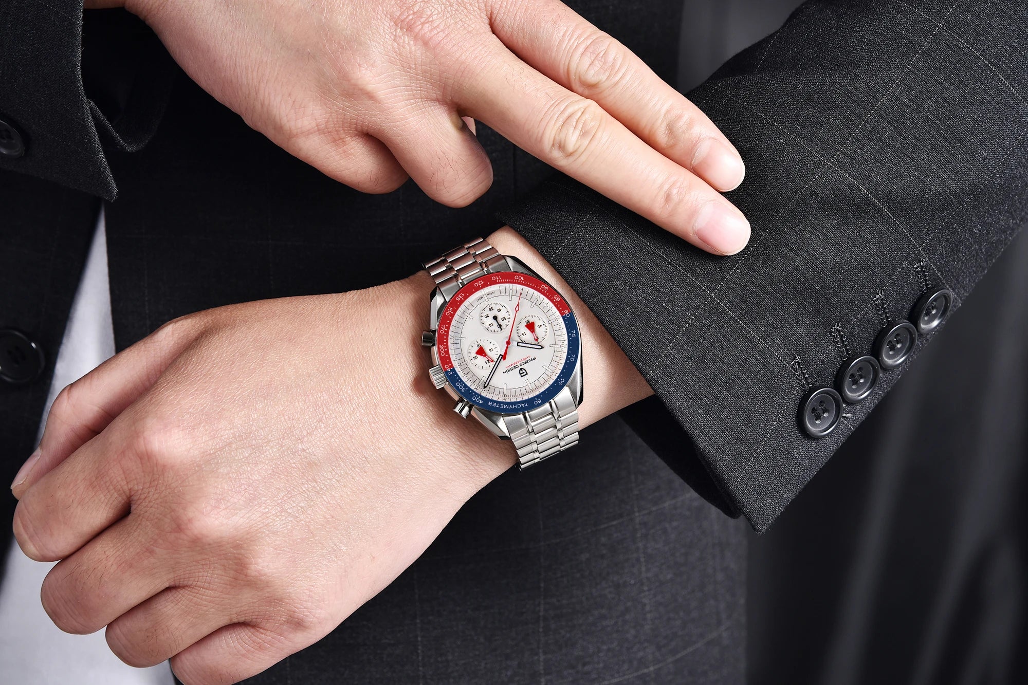Close-up of a person wearing a watch with a red, white, and blue face on a dark suit.
