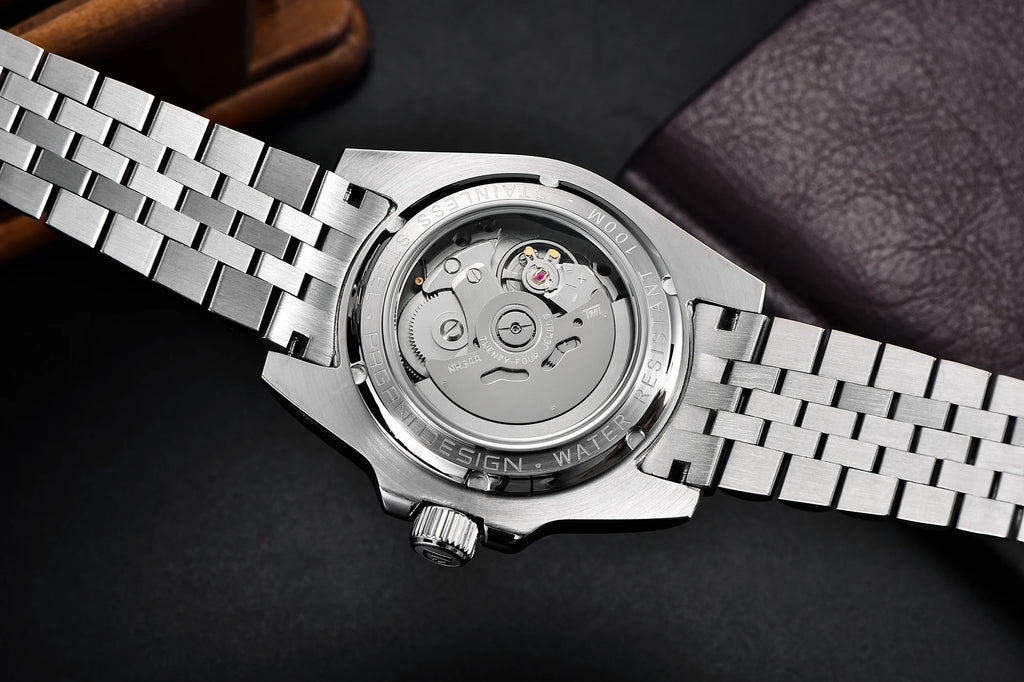 Close-up of a silver watch with a visible mechanical movement on a dark background