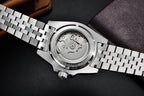 Close-up of a silver watch with a visible mechanical movement on a dark background