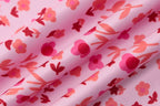 Floral patterned fabric with pink and red flowers on a light pink background