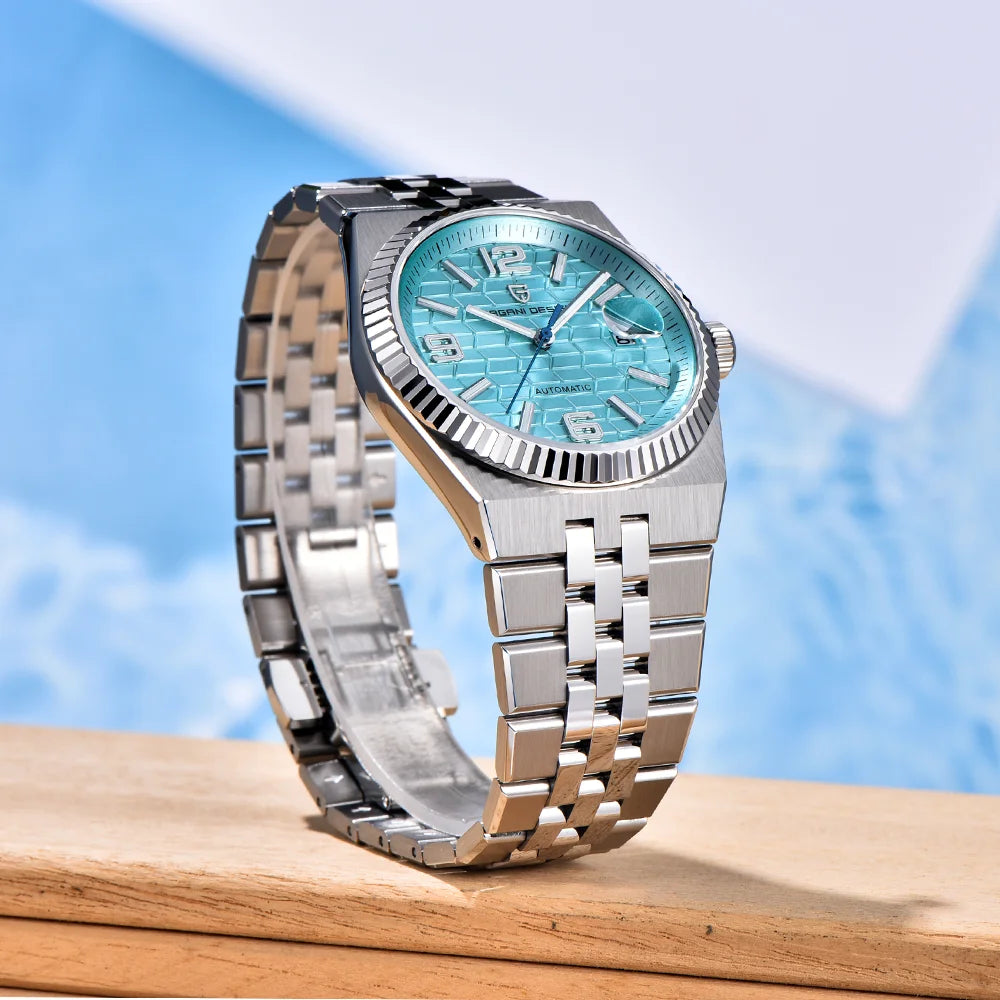 Silver watch with a blue face on a wooden surface with a blue gradient background