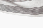 Close-up of a white fabric with thin black stripes on a white background