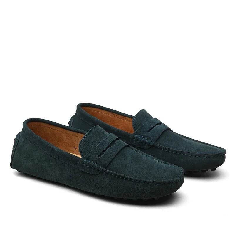 Pair of dark green loafers on a white background