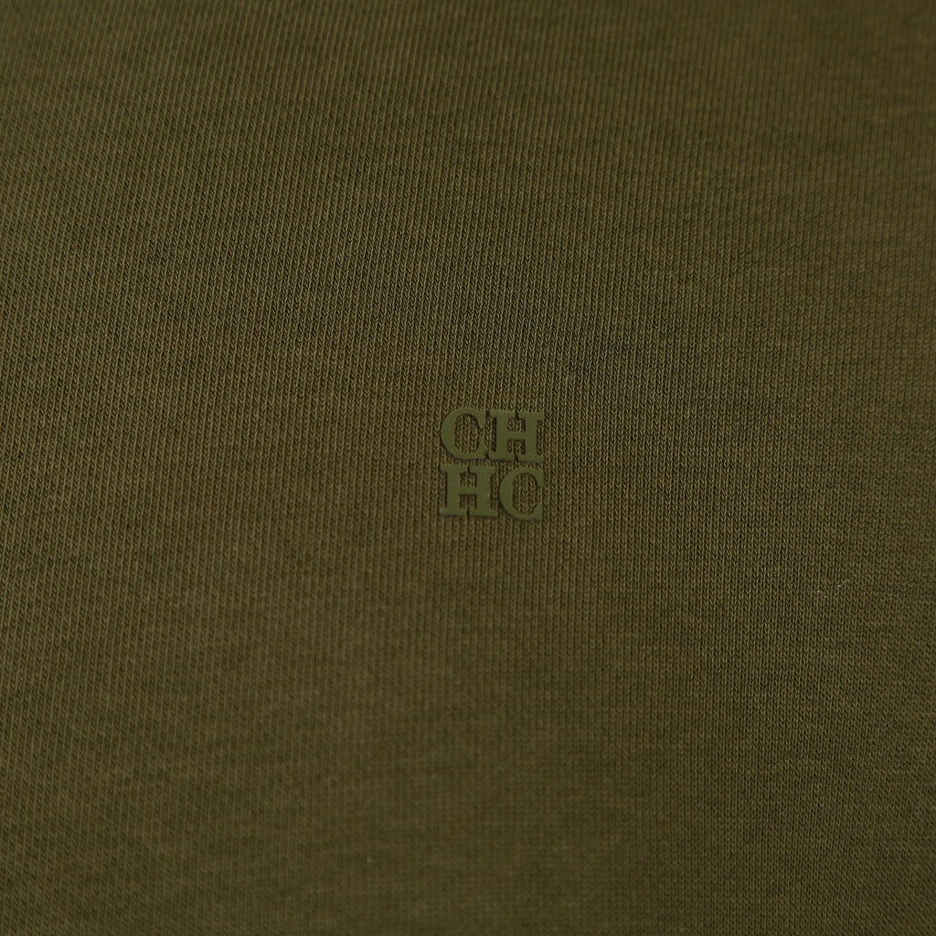 Close-up of a textured brown fabric with a small logo in the center.