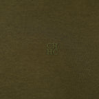 Close-up of a textured brown fabric with a small logo in the center.