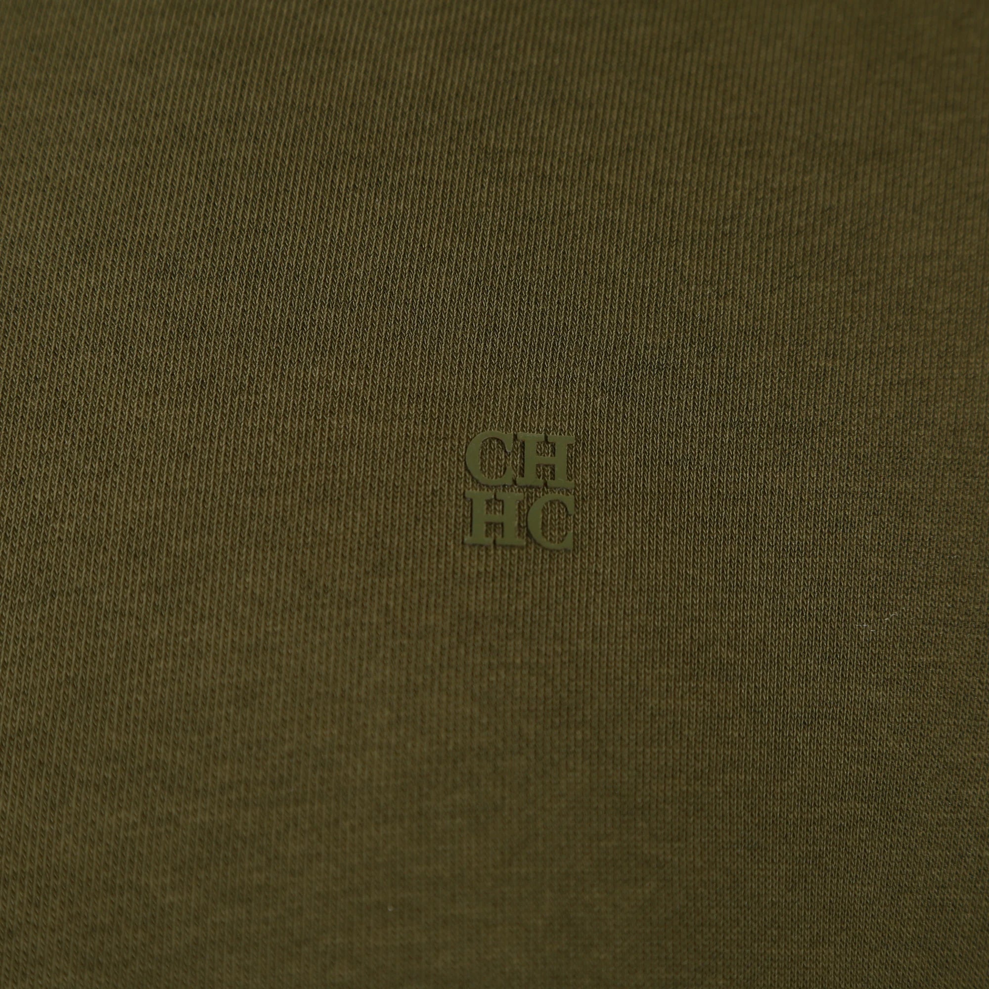 Close-up of a textured brown fabric with a small logo in the center.