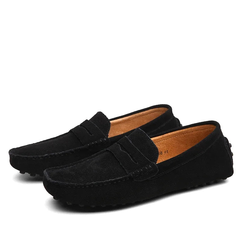 Black loafers with brown soles on a white background