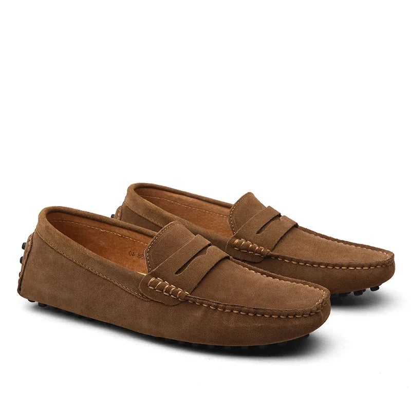 Pair of brown suede loafers on a white background
