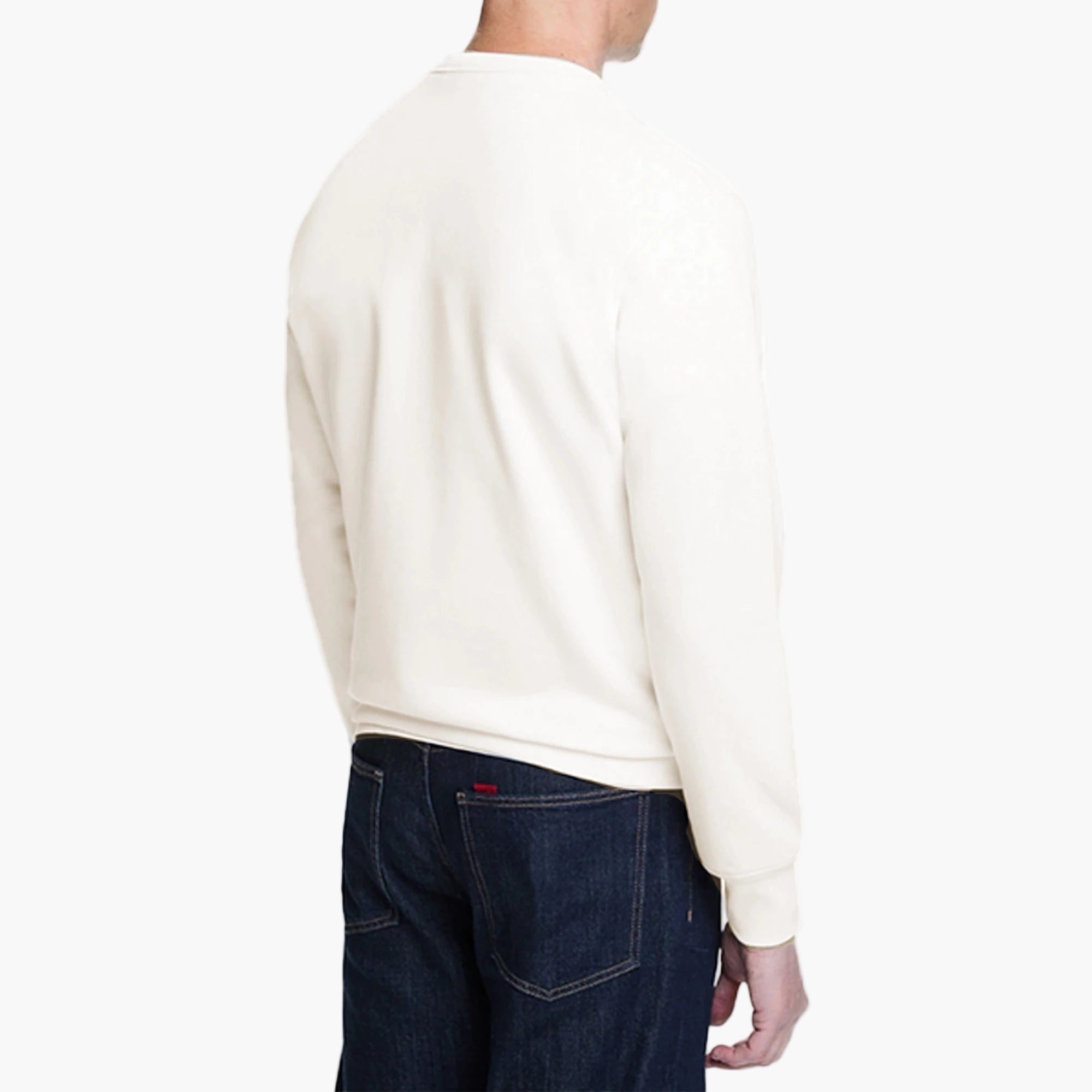 Person wearing a white sweater and dark jeans on a white background
