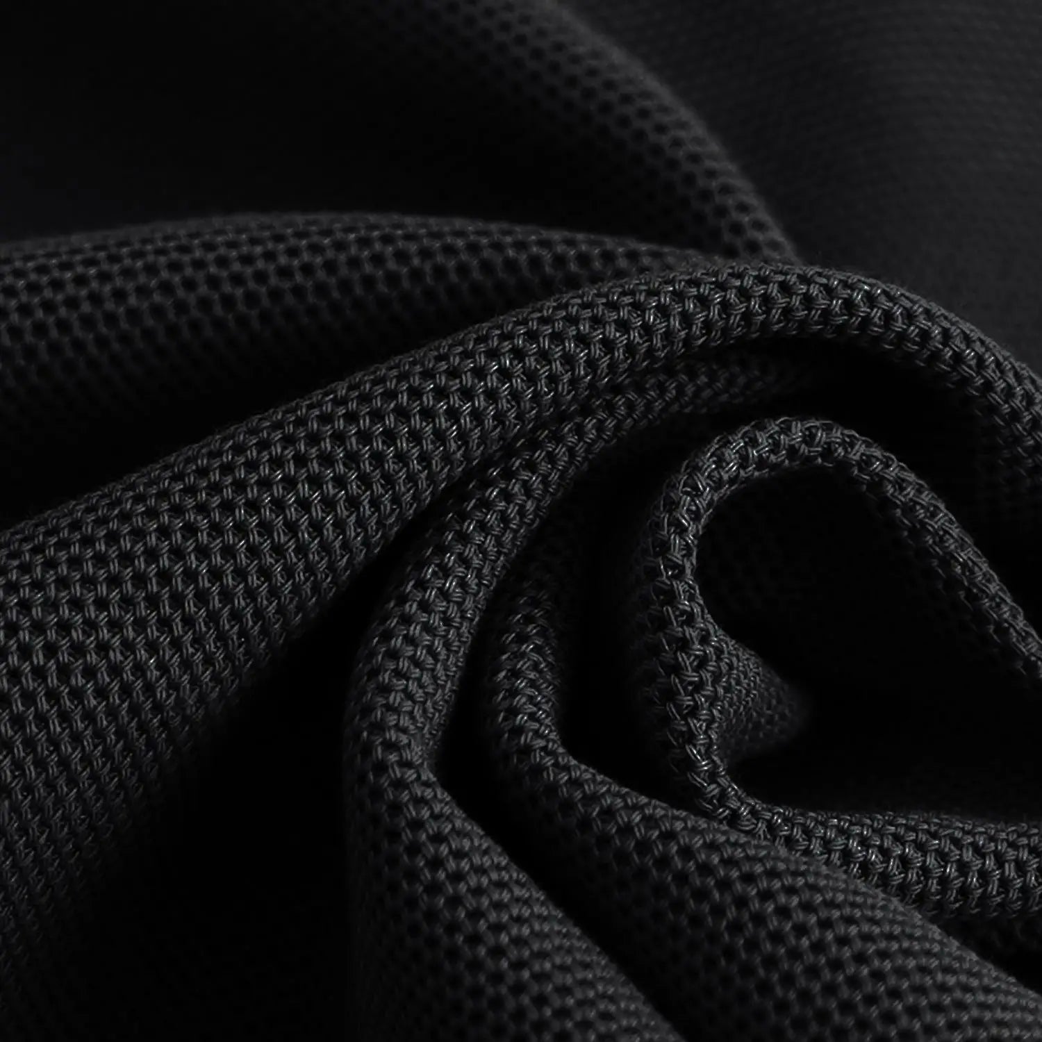 Close-up of textured black fabric with a dark background